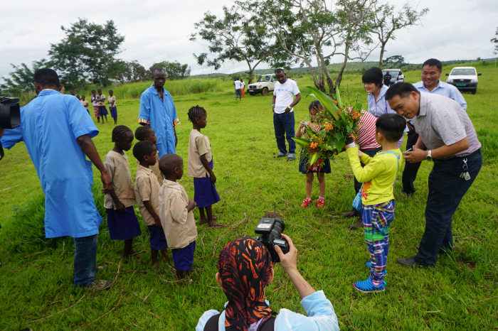 3 爸爸和宝贝们走进了刚果（布）名都里PK10学校，与当地的非洲小朋友开展联谊活动。图为孩子们接受当地小朋友献上的欢迎花束。.jpg
